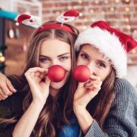 ung-kvinde-laver-ansigter-med-julehat-og-klovnenaeser
